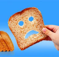 photo of slice pf overprocessed wheat bread with sad face torn out of it