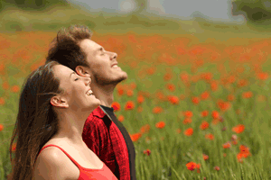 Two people in a field of red flowers after practicing stress reduction techniques