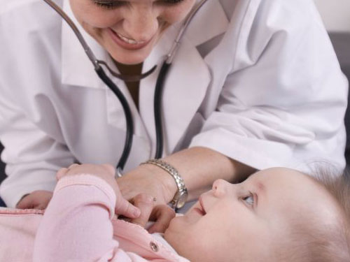 Doctor with stethoscope listening to baby's heart at cherubino health center