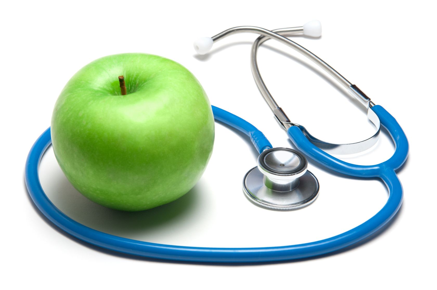 Stethoscope with green apple on white