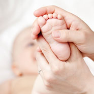 Baby with doctors hand on her foot