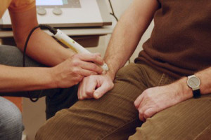 Close-up of electroacupuncture / laser therapy unit being used on a wrist acupuncture point as CAM treatment. And offering ways to Avoid Becoming a Statistic in the Opioid Epidemic