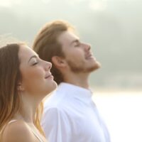 Relaxed couple facing skyward with closed eyes and smiles