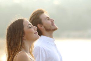 Relaxed couple facing skyward with closed eyes and smiles