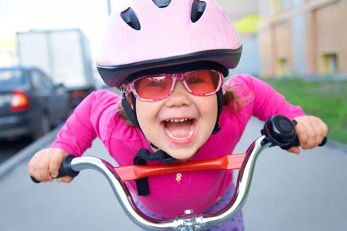 Happy active girl on bicycle wearing helmet